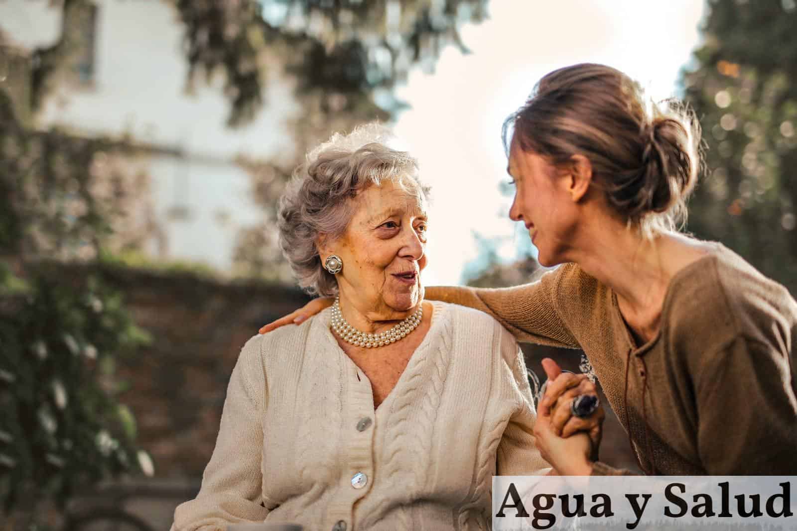 Joyful adult daughter greeting happy surprised senior mother in garden
