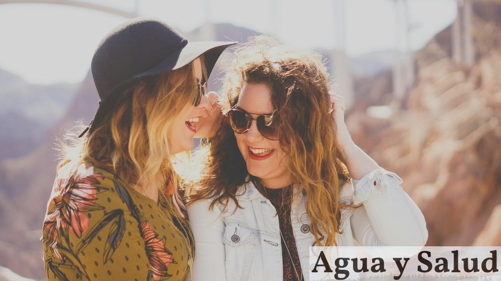 two women smiling while wearing sunglasses